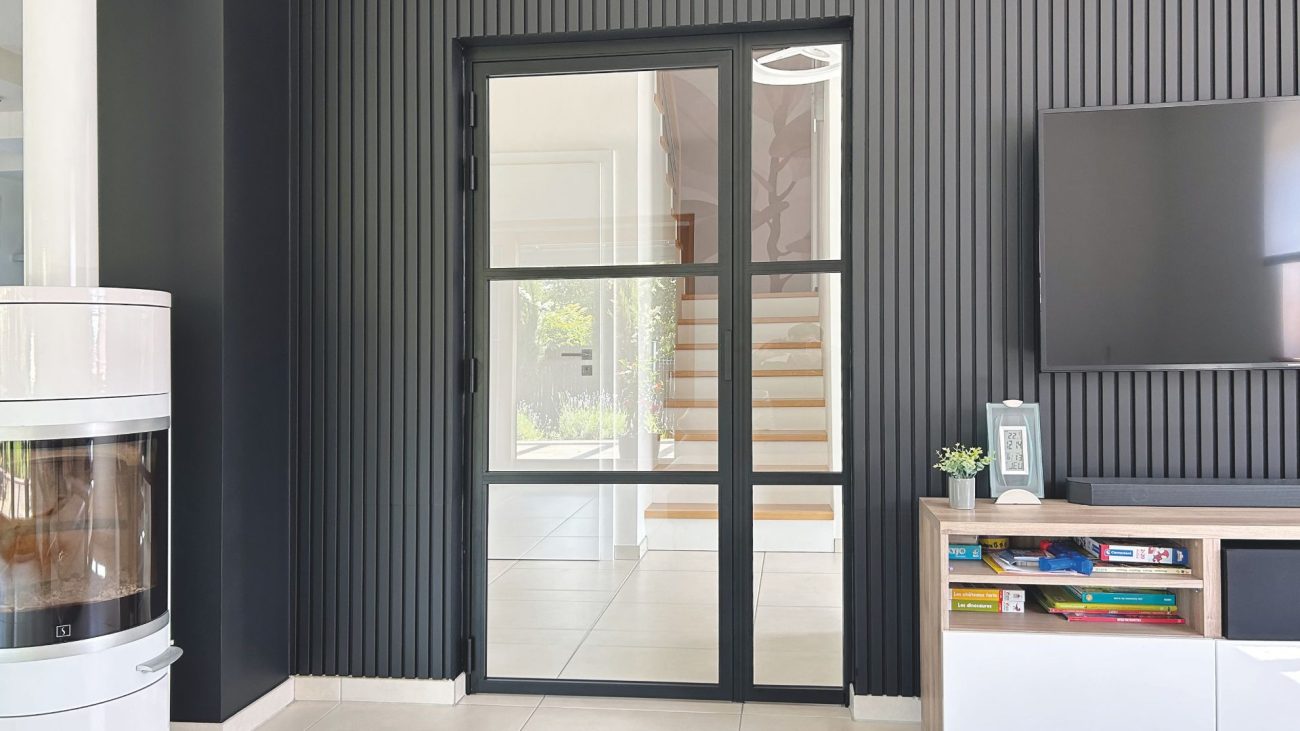 Moderne Loft-Drehtür aus Aluminium und Glas in schwarzem Rahmen als stilvoller Blickfang im Wohnbereich.