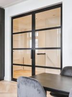 Loft-Drehtür aus Aluminium und Glas als elegante Raumtrennung zwischen Küche und Essbereich.