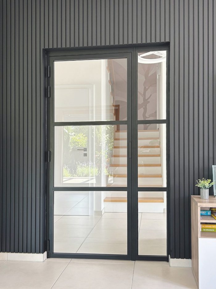 Moderne Loft-Drehtür aus Aluminium und Glas in schwarzem Rahmen als stilvoller Blickfang im Wohnbereich.